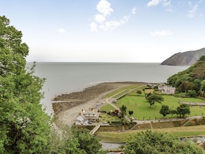 En kystby med strand, golfbane og et stort hus med have.