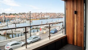 Een balkon met uitzicht op een jachthaven en een stad.