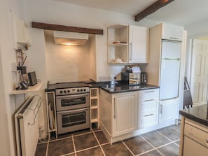 A compact kitchen with a built-in oven, a microwave, and a refrigerator. - A River Runs By (Kendal)