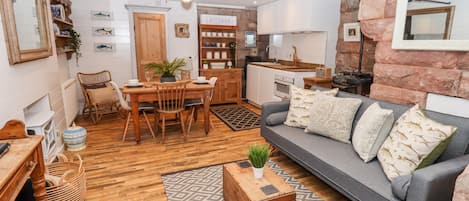 A compact living space with a dining area, sofa, and kitchenette.
