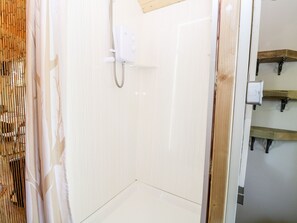 A bathroom with a shower, a toilet, and a sink. - Hugatree (King's Lynn)