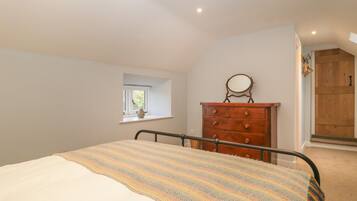 Un dormitorio con cama, cómoda, ventana y puerta.