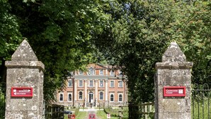 A historic building with a red sign indicating the main entrance and deliveries. - The Outlook (Taunton)