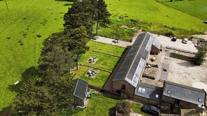 An aerial view of a property with a large barn, a fenced yard, and a small house. - Shepherd's Crook (Harrogate)