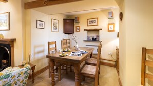 A cozy dining area with a wooden table, four chairs, and a fireplace.