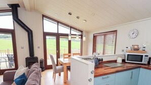 Une cuisine moderne dotée d’un îlot central, un coin repas avec une table et des chaises, et un salon confortable avec un canapé.
