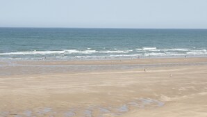 A wide beach with a clear sky. - Banadlen Lodge (Brynteg)