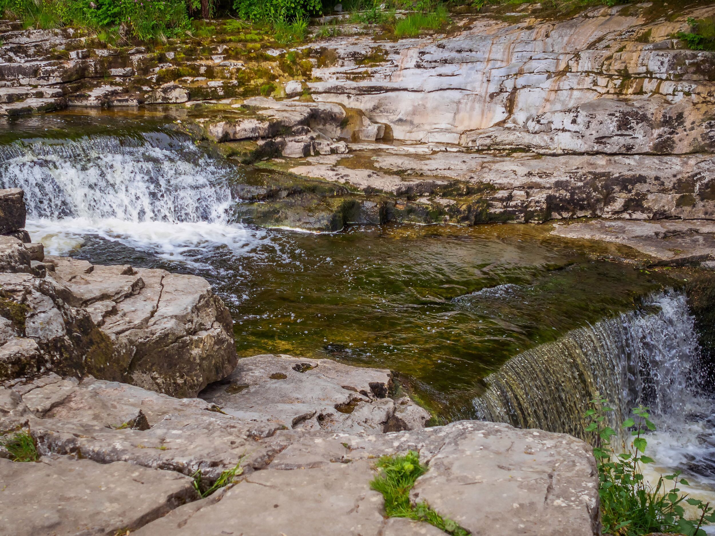 A natural rock formation with a small waterfall.
