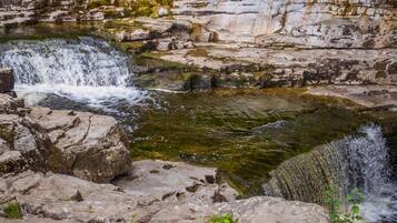 A natural rock formation with a small waterfall.