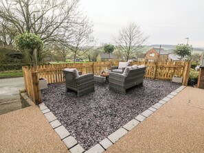 An outdoor seating area with wicker furniture and a wooden fence.
