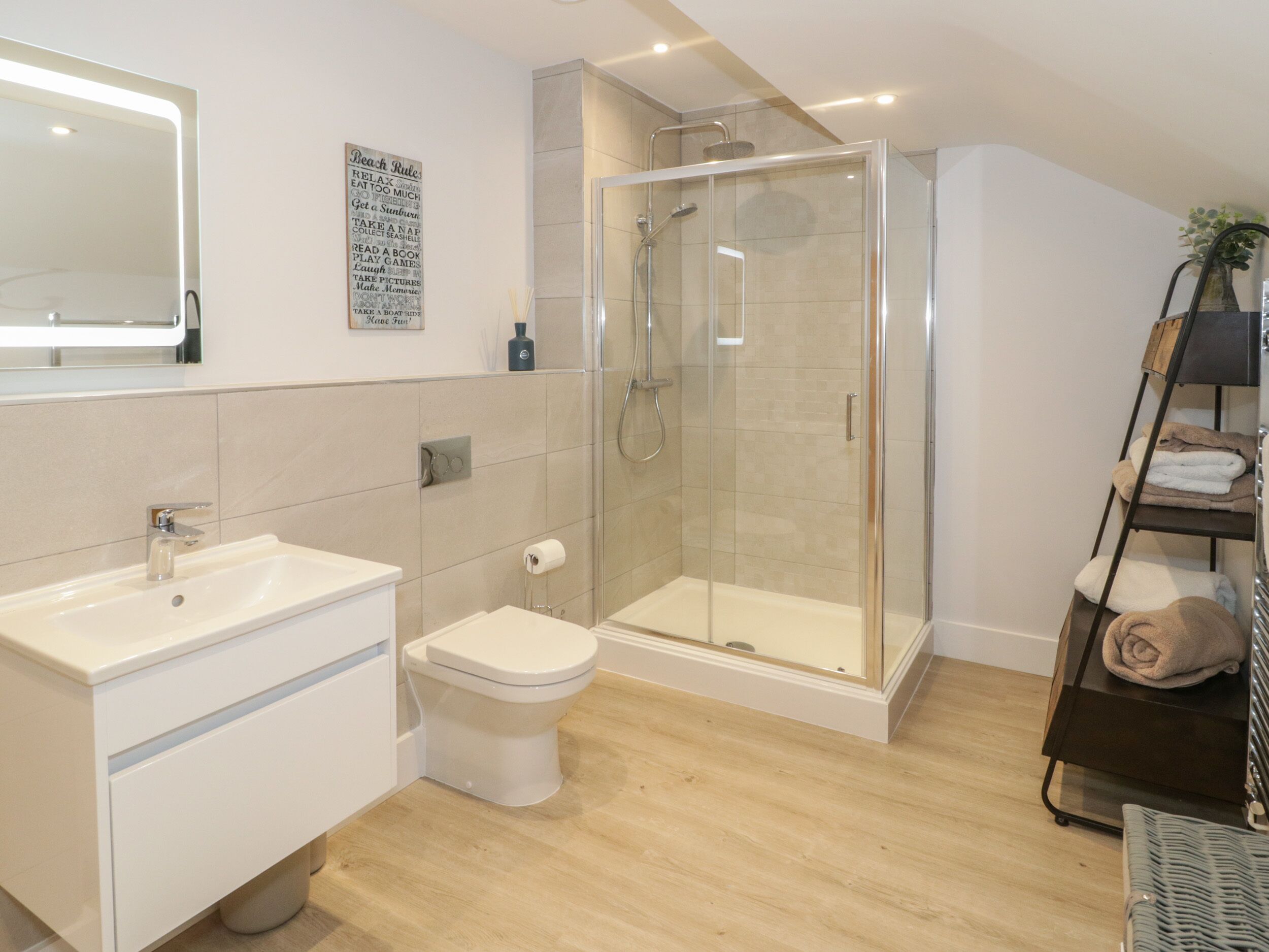 Un baño moderno con ducha de vidrio, lavamanos y retrete.