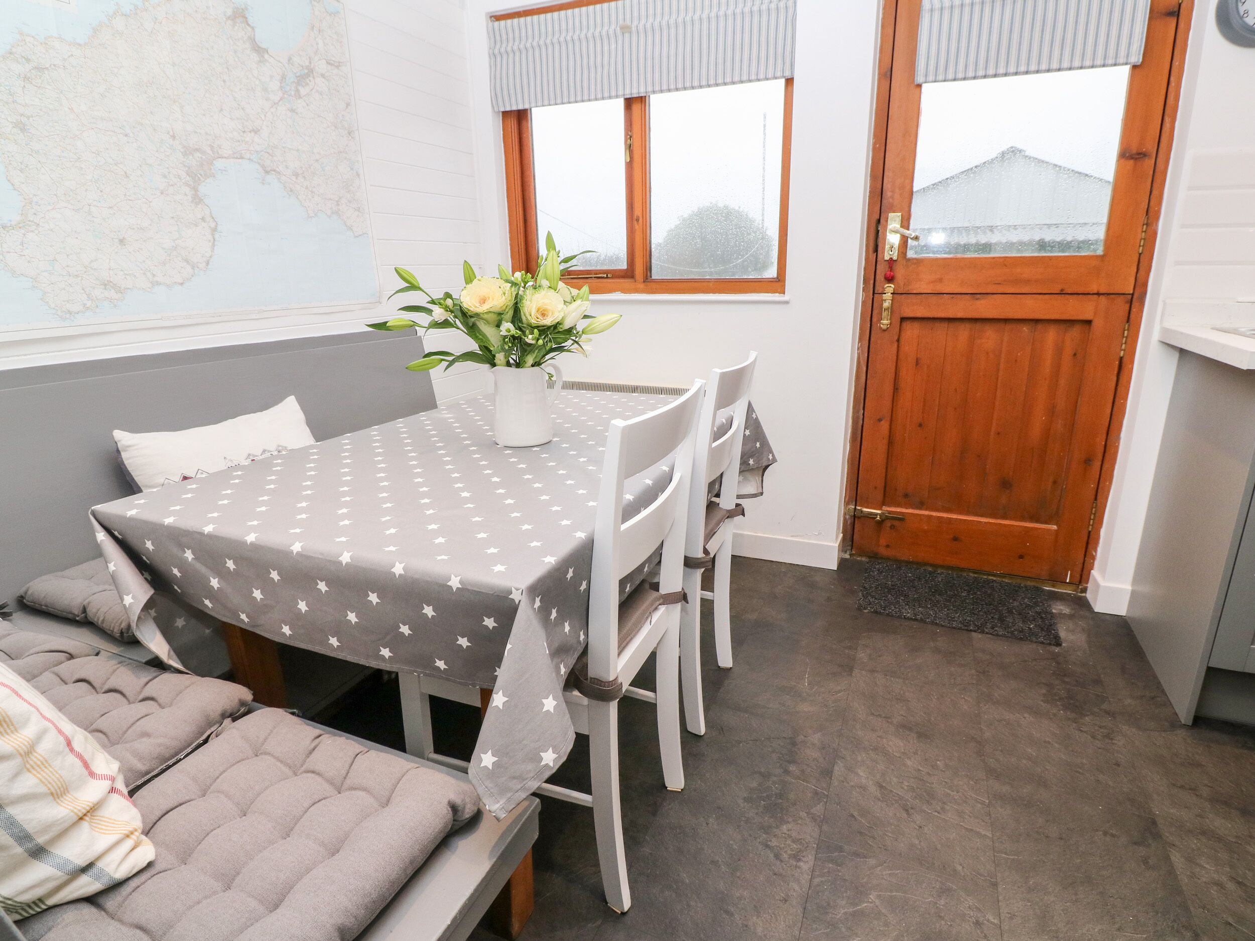 Une pièce confortable avec un lit, une table à manger et des chaises, une porte en bois et une carte accrochée au mur.
