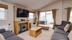 Een woonkamer met een televisie, bank en open haard.