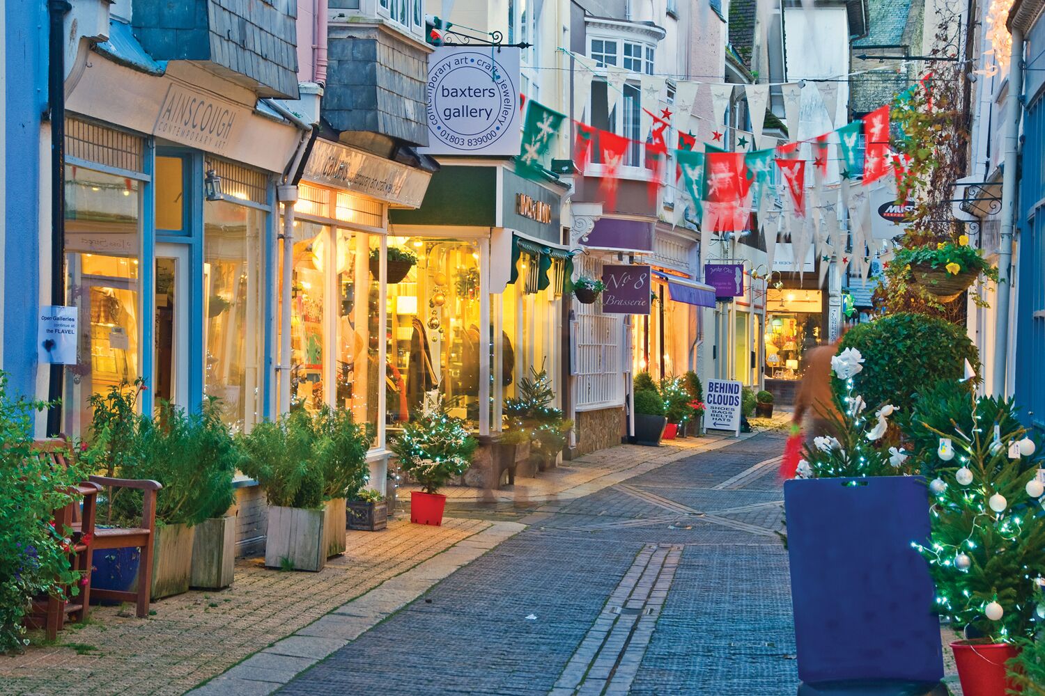A narrow street lined with shops, including a jewelry gallery and a boutique.