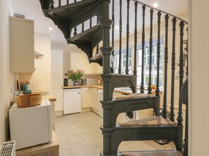 A kitchen with a staircase, a refrigerator, and a sink. - Maisie's Cottage (Dunblane)