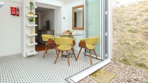 A modern interior with a dining area featuring yellow chairs, a glass table, and a skylight above.