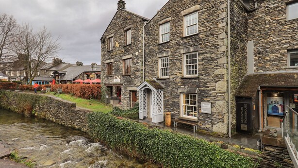 Un bâtiment en pierre abritant un pub appelé « Flying Fleece » et portant une enseigne indiquant « Idle Mill ».