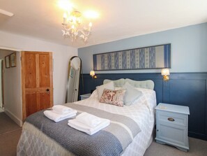 A bedroom with a bed, bedside tables, a mirror, and a chandelier. - 3 Rock Cottages (Kingsbridge)