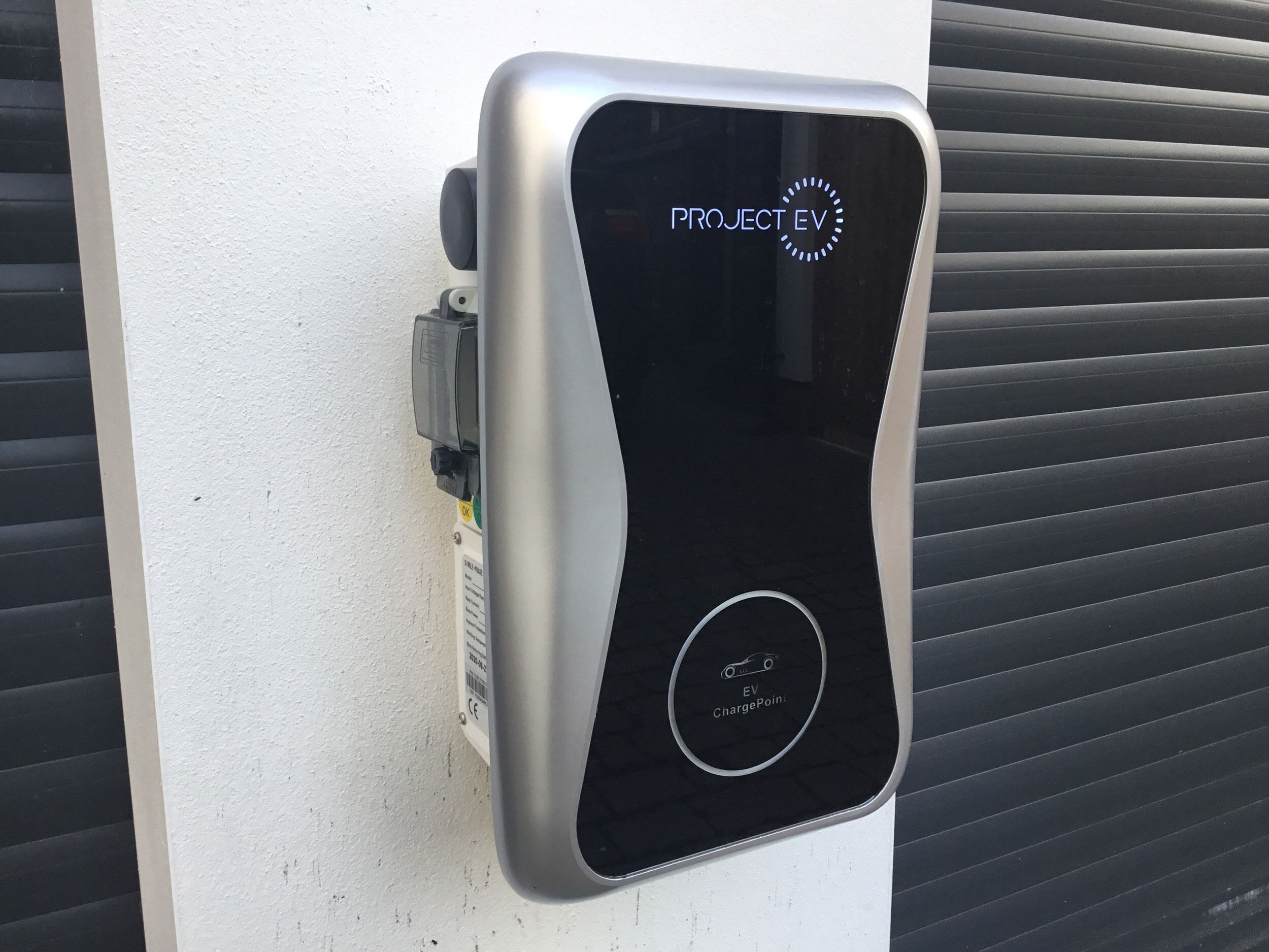 A PROJECT EV electric vehicle charging station with a sleek design, a digital display, and an EV ChargePoint symbol.