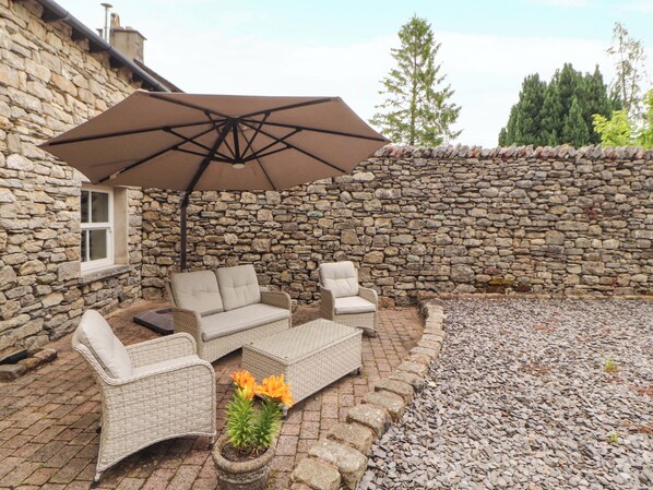 A stone wall, wicker furniture, and a potted plant.