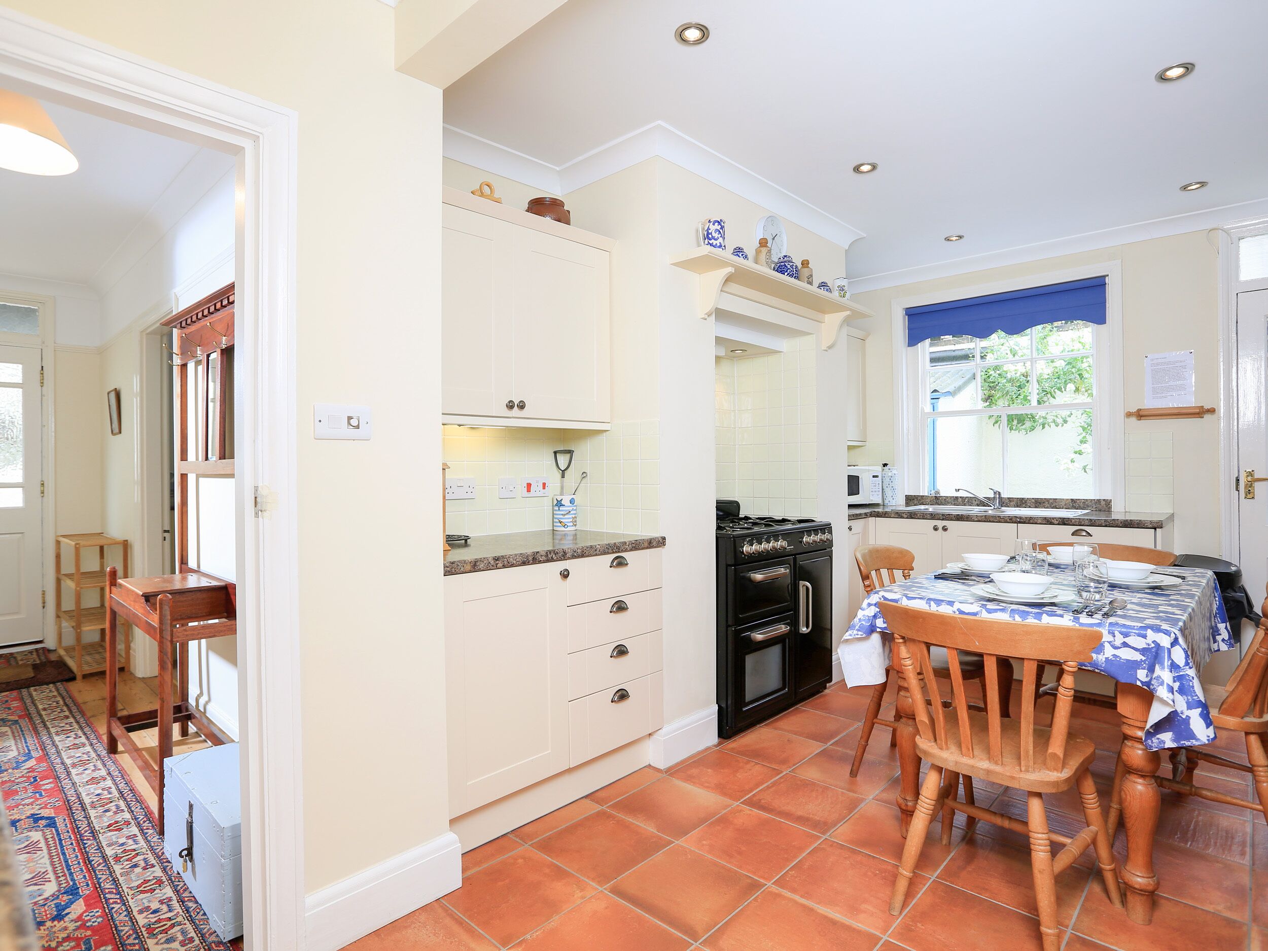 A compact kitchen with white cabinets, a stove, and a dining area with a table set for two.