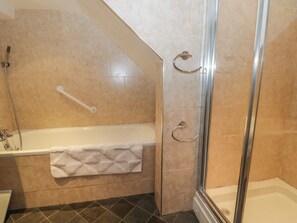 A bathroom with a bathtub, a shower, and a glass-enclosed shower stall. - Helredale Retreat Whitby (Whitby)