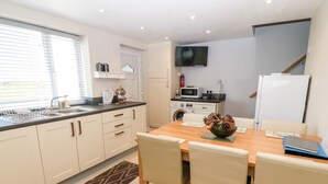 A modern kitchen with a dining area, including a sink, microwave, and stove.