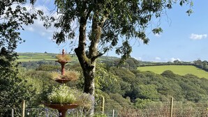 Un giardino con fontana a più livelli, immerso nel verde rigoglioso e con vista su dolci colline.