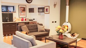 A modern living room with a sofa, coffee table, and a fireplace. - Bank House Barn (Shrewsbury)