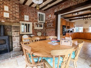 Una cocina rústica con paredes de ladrillo visto, muebles de madera y una chimenea de piedra.