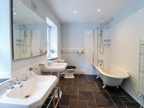 A modern bathroom with a sink, toilet, and bathtub. - Mor Edrin (Talsarnau)