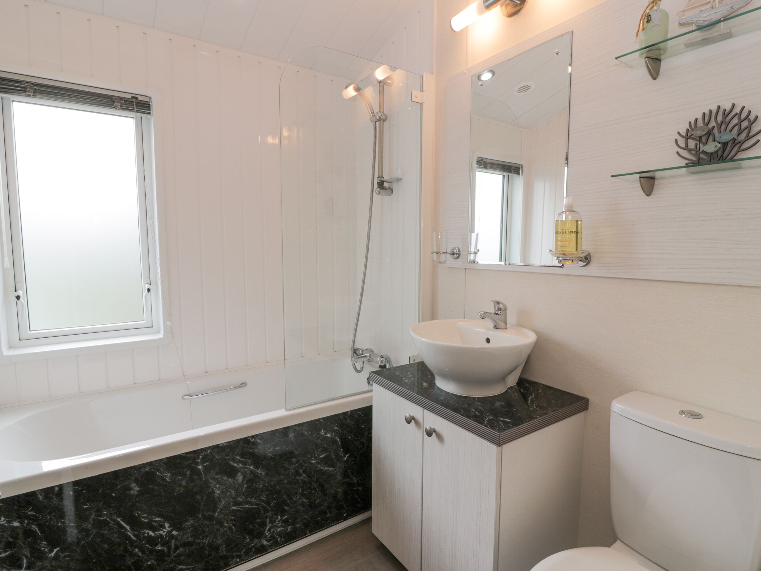 Un baño moderno con bañera, lavamanos e inodoro.