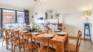 A dining area with wooden furniture, a chandelier, and a view of the outside. - Fields Farm (Stoke-on-Trent)