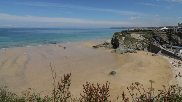 Une plage avec un ciel dégagé et une mer calme.