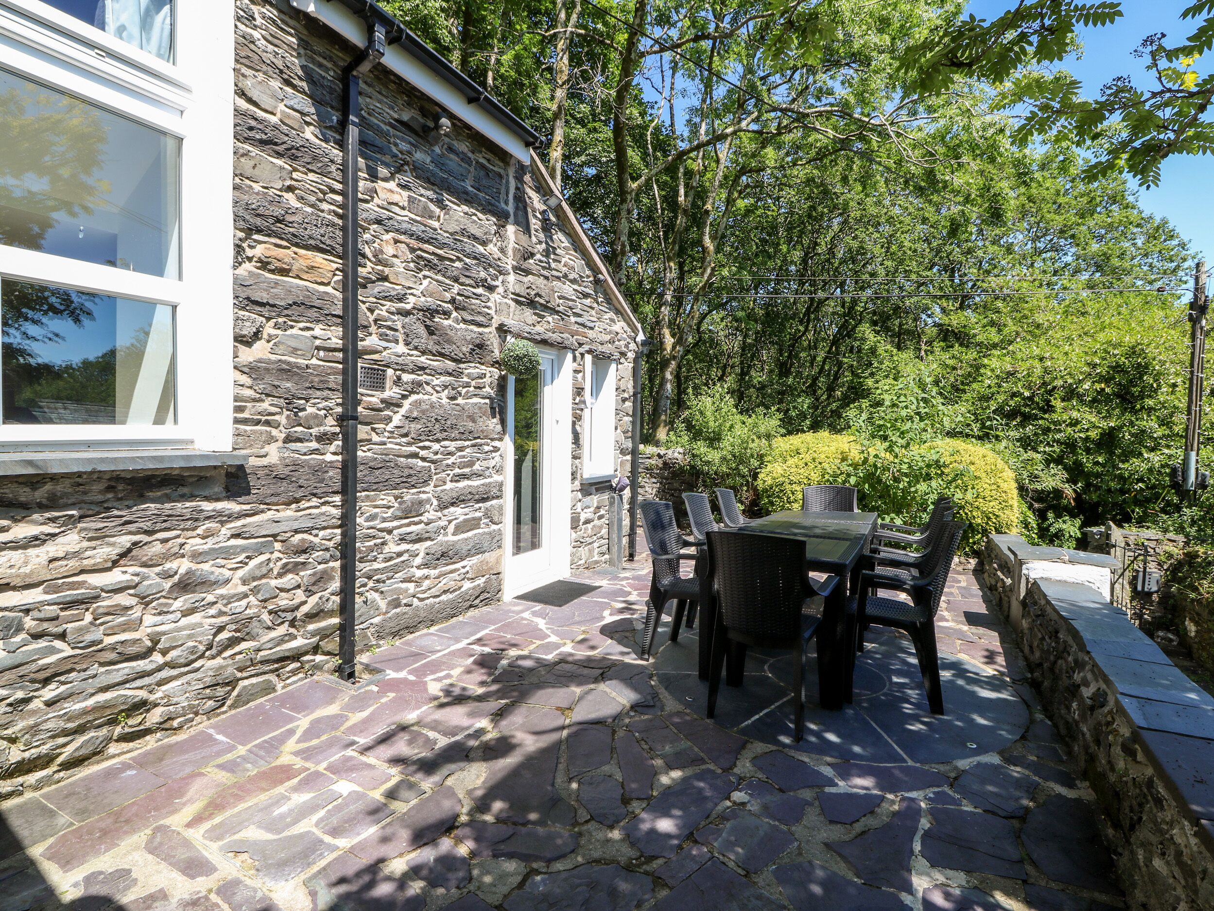 A stone building with a patio area featuring a table and chairs.