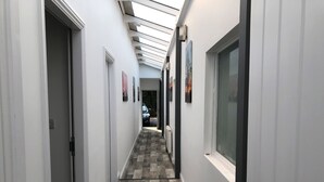 A narrow hallway with a checkered floor, white walls, and a skylight. - 1 Barn Cottages (Whitchurch)
