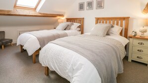 A bedroom with two beds, a skylight, and a small desk with a chair. - Pottergill (Windermere)