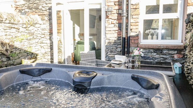 A stone building with a hot tub in the foreground. - Pottergill (Windermere)