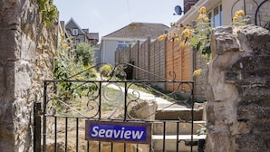 A metal gate with a 'Seaview' sign, stone walls, and a wooden fence. - Seaview (Swanage)