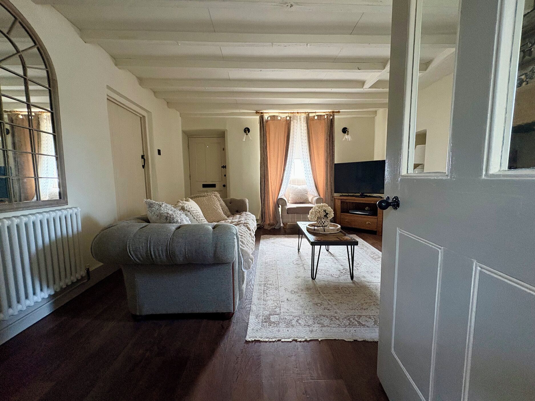 Una sala de estar acogedora con un sofá, una mesa de centro y un televisor al fondo.