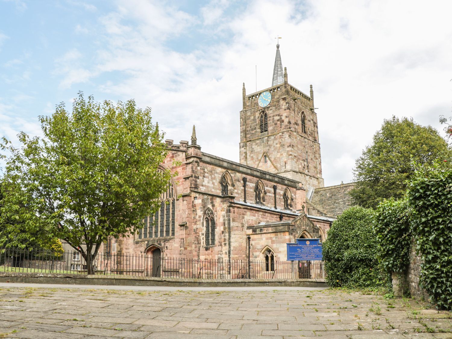 Een historische kerk met een hoge toren en een klok.