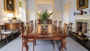 Un comedor formal con una gran mesa de madera, sillas y una chimenea.