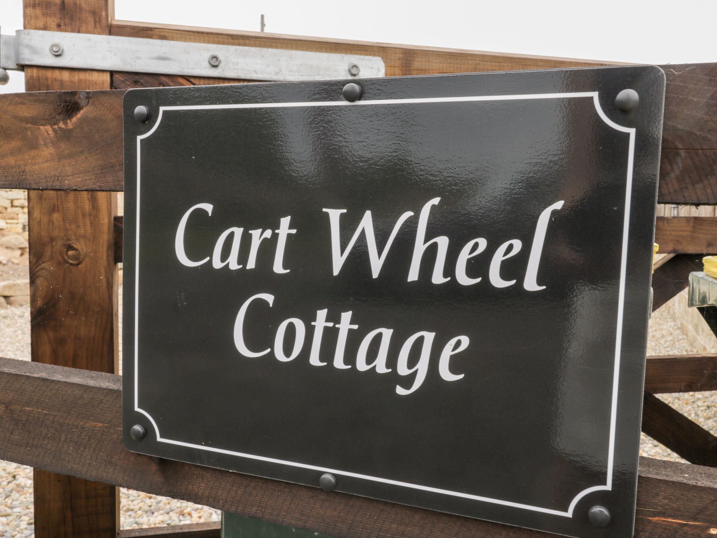 A sign that reads "Cart Wheel Cottage."