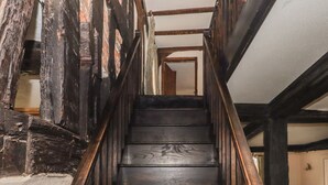 A wooden staircase with dark wooden steps and a handrail, leading to an upper floor. - Top Farm House (Oswestry)