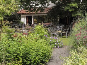 Un jardín con patio, mobiliario exterior y una fuente.