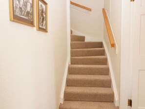 A staircase with carpeted steps and a wooden handrail, leading to a door. - Branklyn Garden Cottage (Perth)