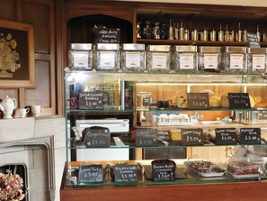 A bakery display with various baked goods and a selection of teas. - Branklyn Garden Cottage (Perth)