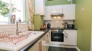 Una cocina con un lavamanos, estufa, horno y armarios.