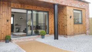 A building with a brick facade, wooden exterior, and a glass entrance. - Owl's Hoot (Hull)