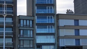 Un immeuble à plusieurs étages doté de balcons et de grandes fenêtres.